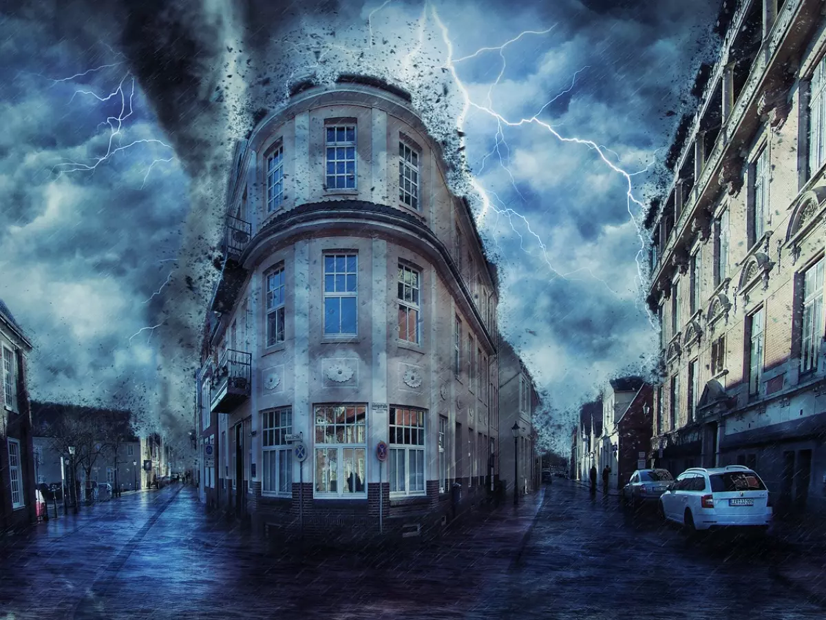 A dramatic scene of a tornado ripping through a city street, with debris flying through the air and buildings in the background.