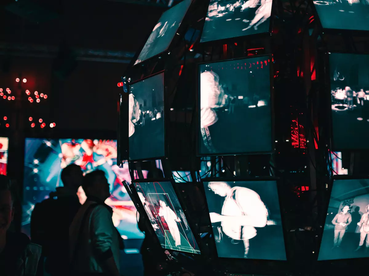 A large, spherical structure with multiple screens displaying various scenes, likely from security cameras. The screens are in a grid-like pattern, suggesting a network of surveillance.