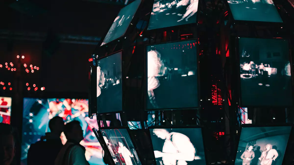 A large, spherical structure with multiple screens displaying various scenes, likely from security cameras. The screens are in a grid-like pattern, suggesting a network of surveillance.