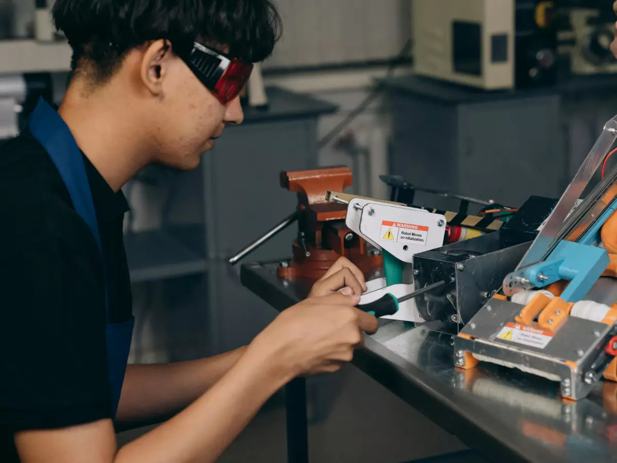 A person is working on a machine with wires and components