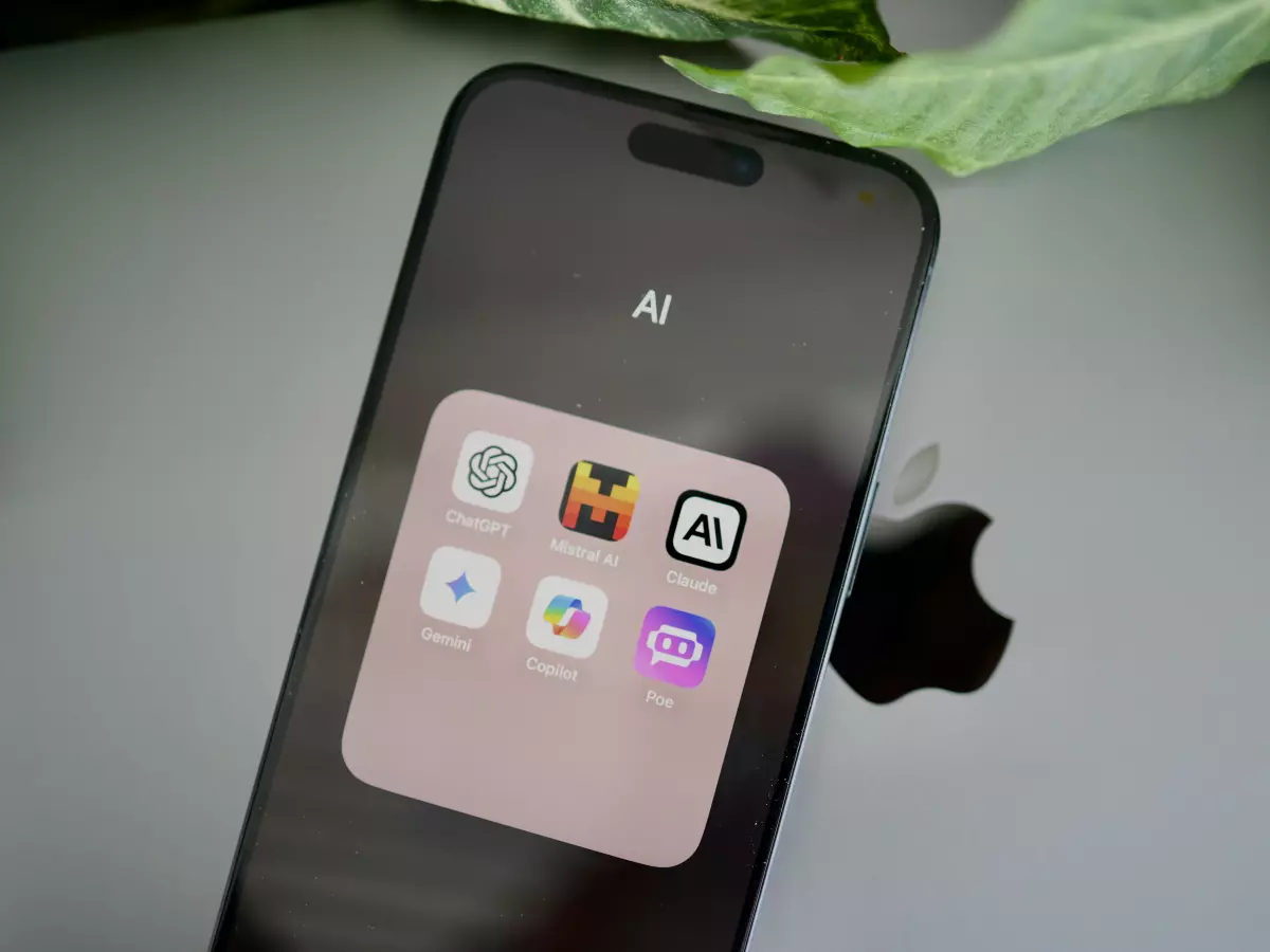 An iPhone displaying a home screen with various icons, including one labeled AI, along with a leaf. The AI app icon depicts a stylized brain surrounded by a hexagon shape, representing the connection between technology and human intellect.