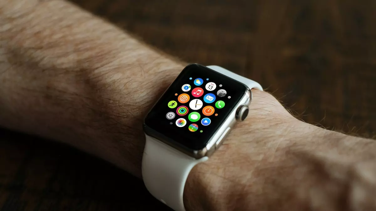 A white Apple Watch on a man