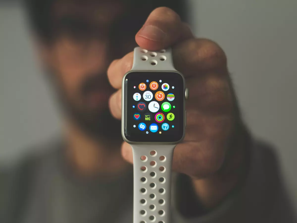 A close-up shot of an Apple Watch Series 8 with a white band. The watch face is showing the time and some app icons.