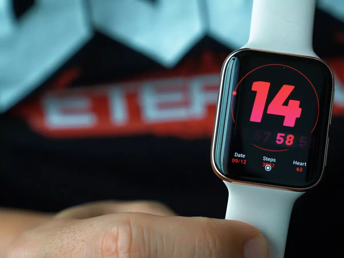 A close-up shot of an Apple Watch on a person's wrist. The watch face is white and the numbers are red. 