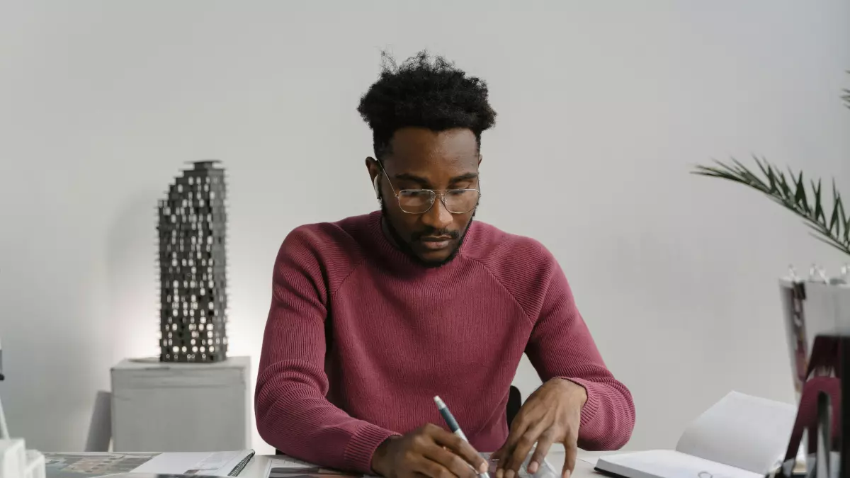 A person is sitting at a desk designing a PC. They