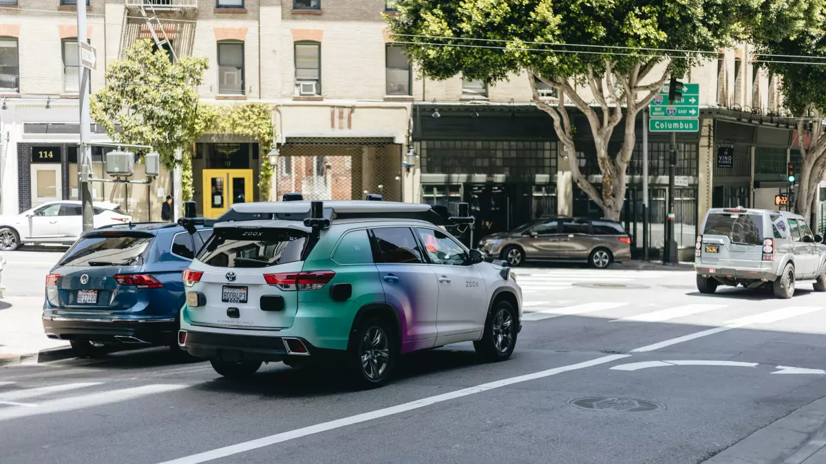 Tesla Model X driving on a road with a person in the driver seat.