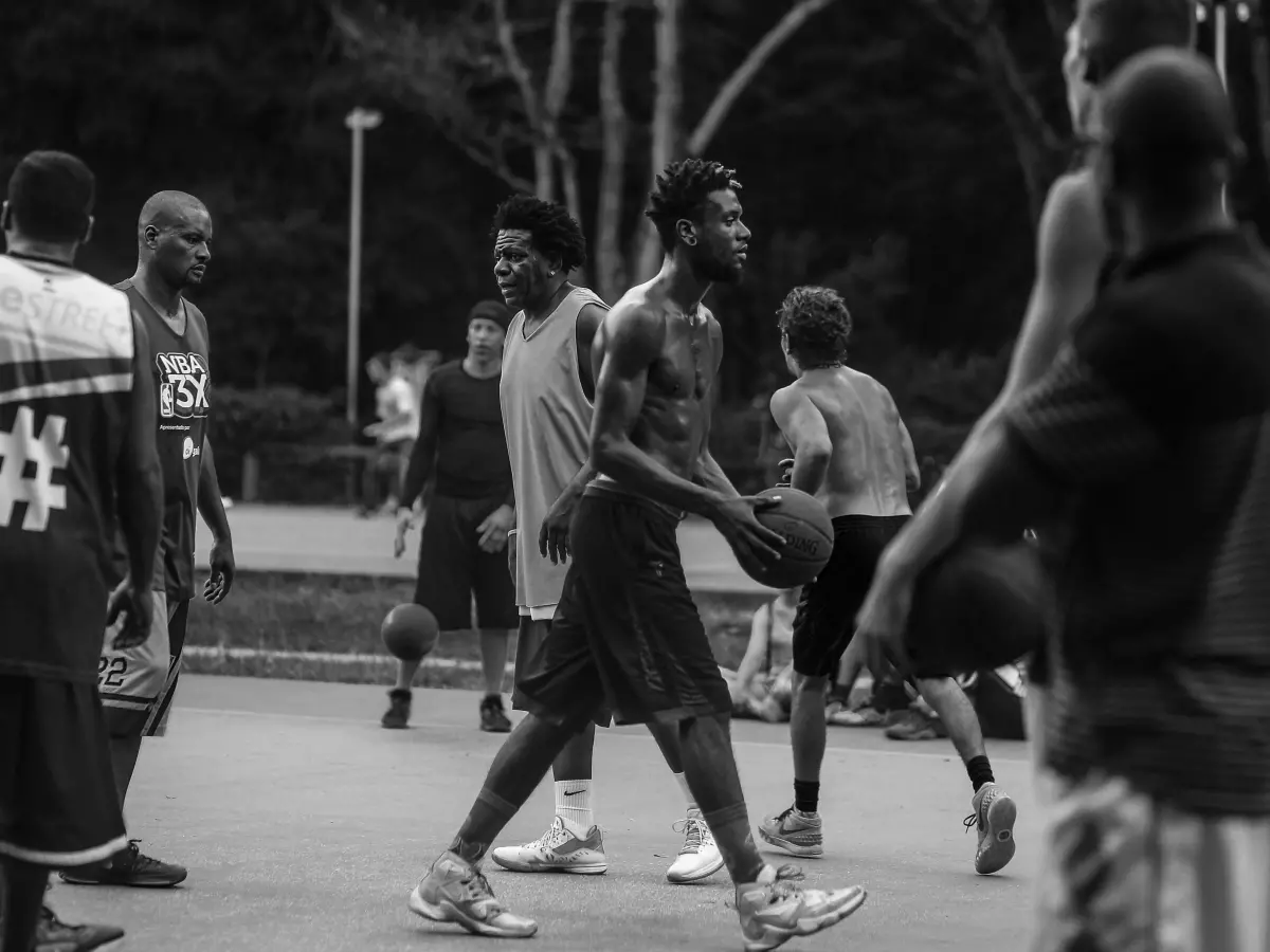 A group of young men are playing basketball on a court.