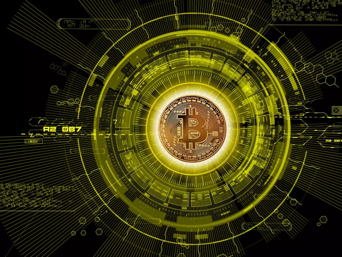 A single Bitcoin coin is placed at the center of a futuristic, circular, digital interface, surrounded by glowing lines and patterns that radiate outwards. The coin is the focal point, radiating a golden hue against a black background.