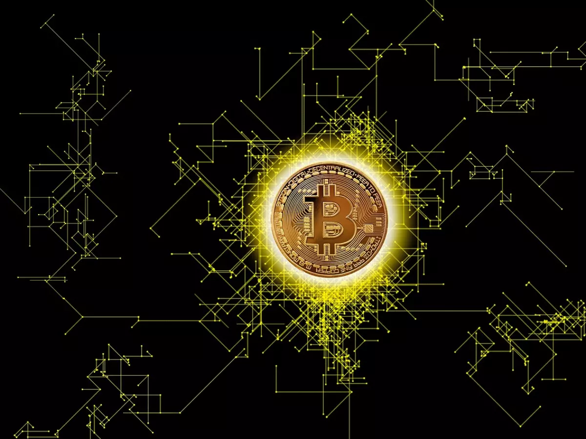 A golden Bitcoin coin with a glowing effect, surrounded by a network of yellow lines on a black background. The lines represent the Bitcoin network.