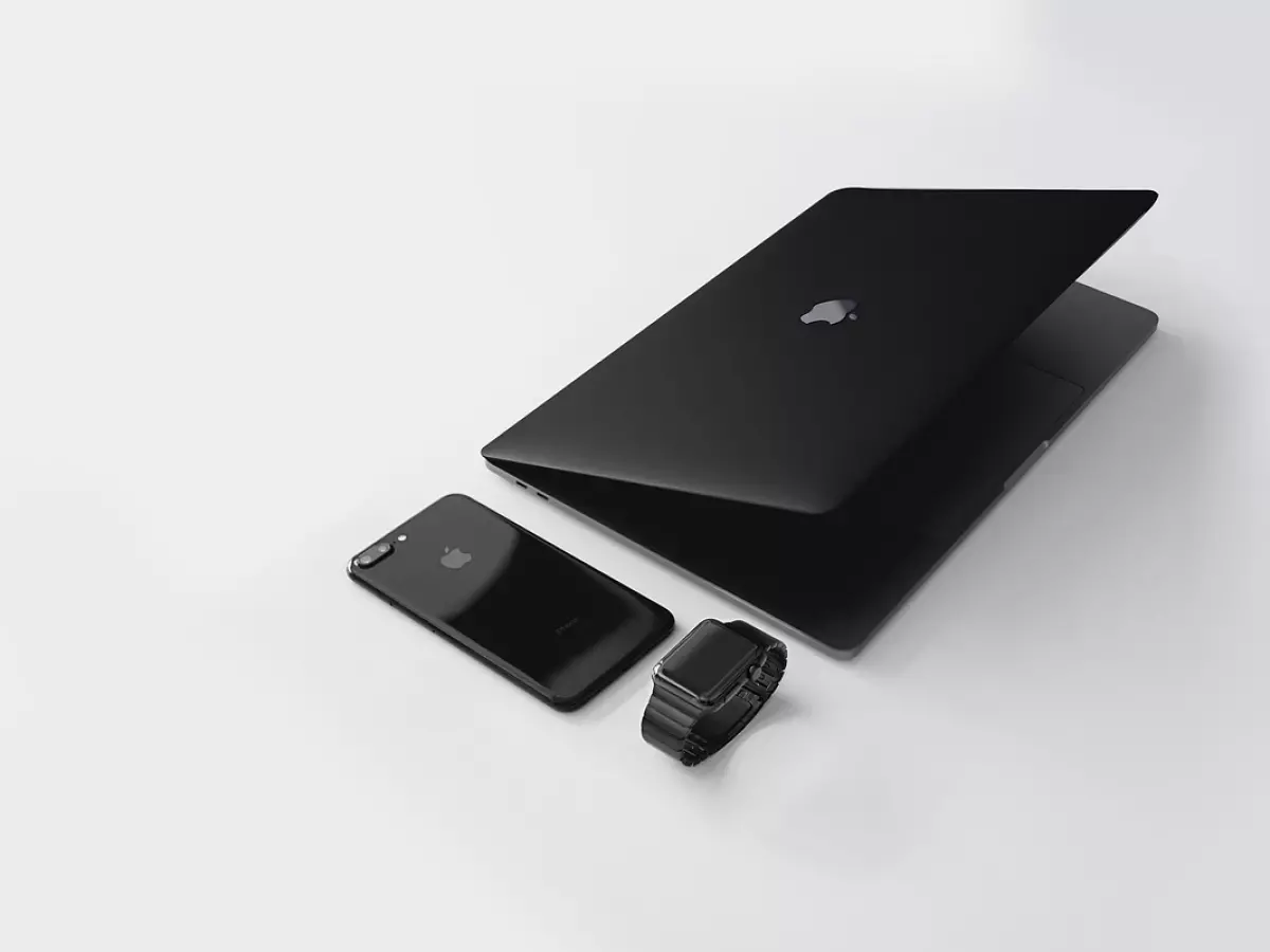 A black laptop, a black smartphone, and a black smartwatch on a white background.