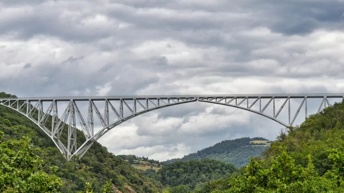 A large steel bridge with a single arch spanning a valley.