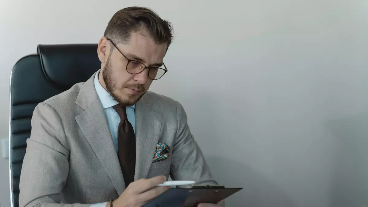 A man in a suit looking at papers in a business setting.