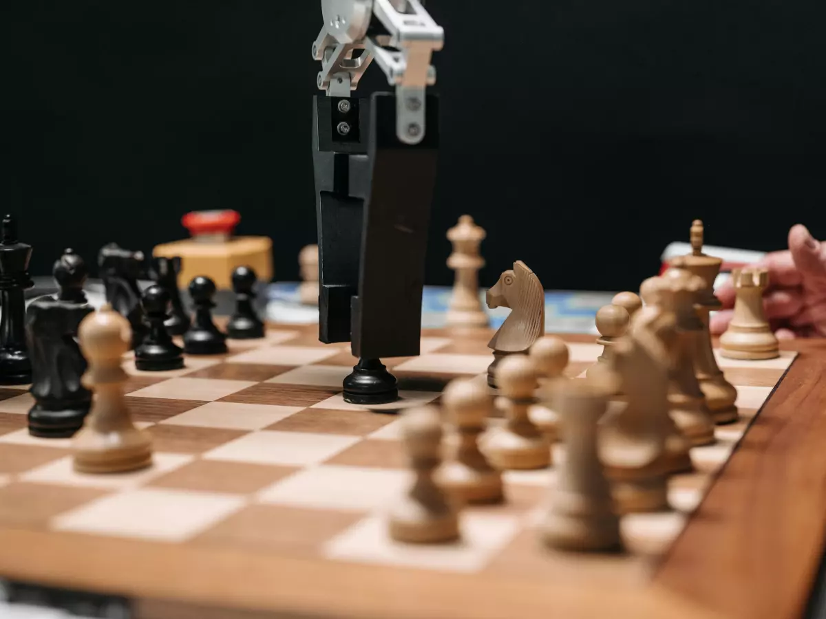 A robotic arm moving a chess piece during a game.