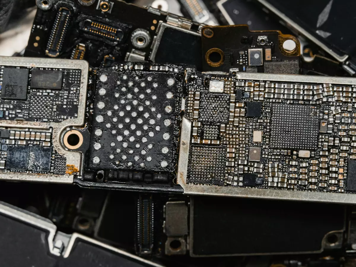 Close-up of a circuit board with various components, featuring intricate patterns and solder points. The board is partially obscured by other components, highlighting the dense nature of modern electronics.