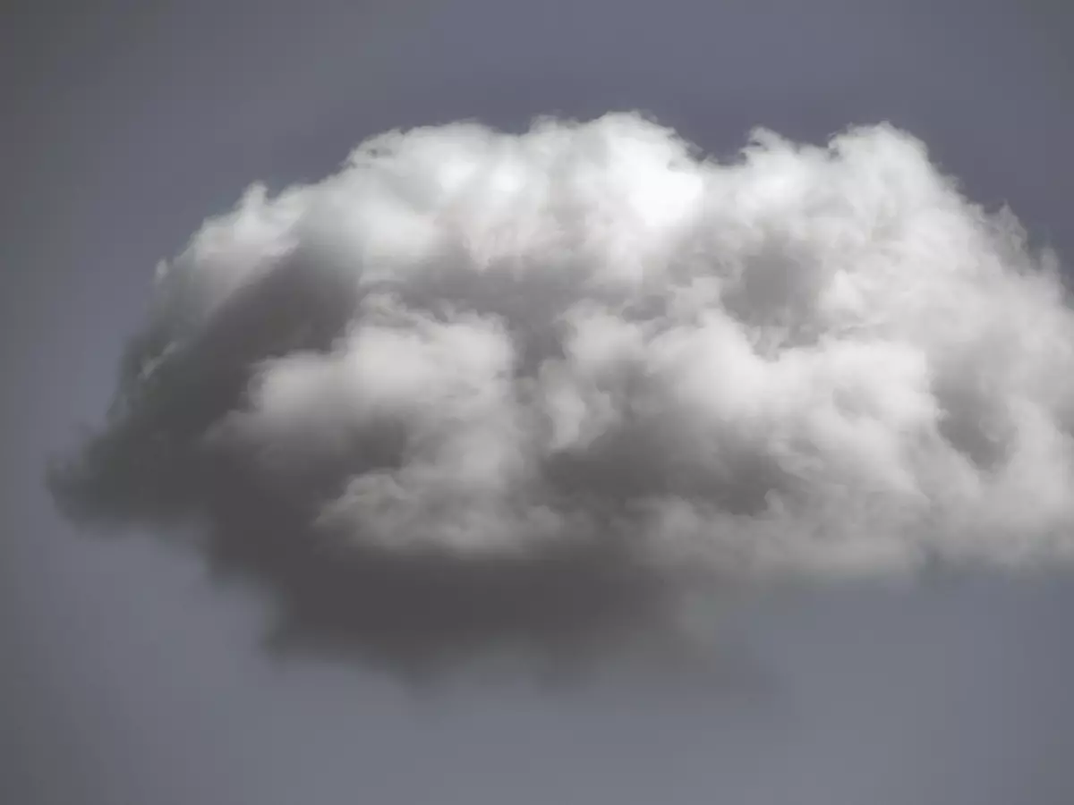 A close-up of a single, white, fluffy cloud isolated against a gray sky.