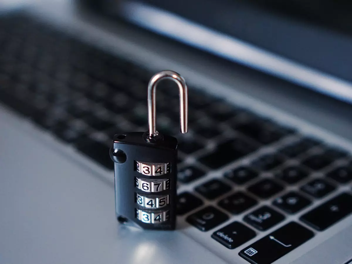 A padlock is on a laptop keyboard, the number combination can be seen.