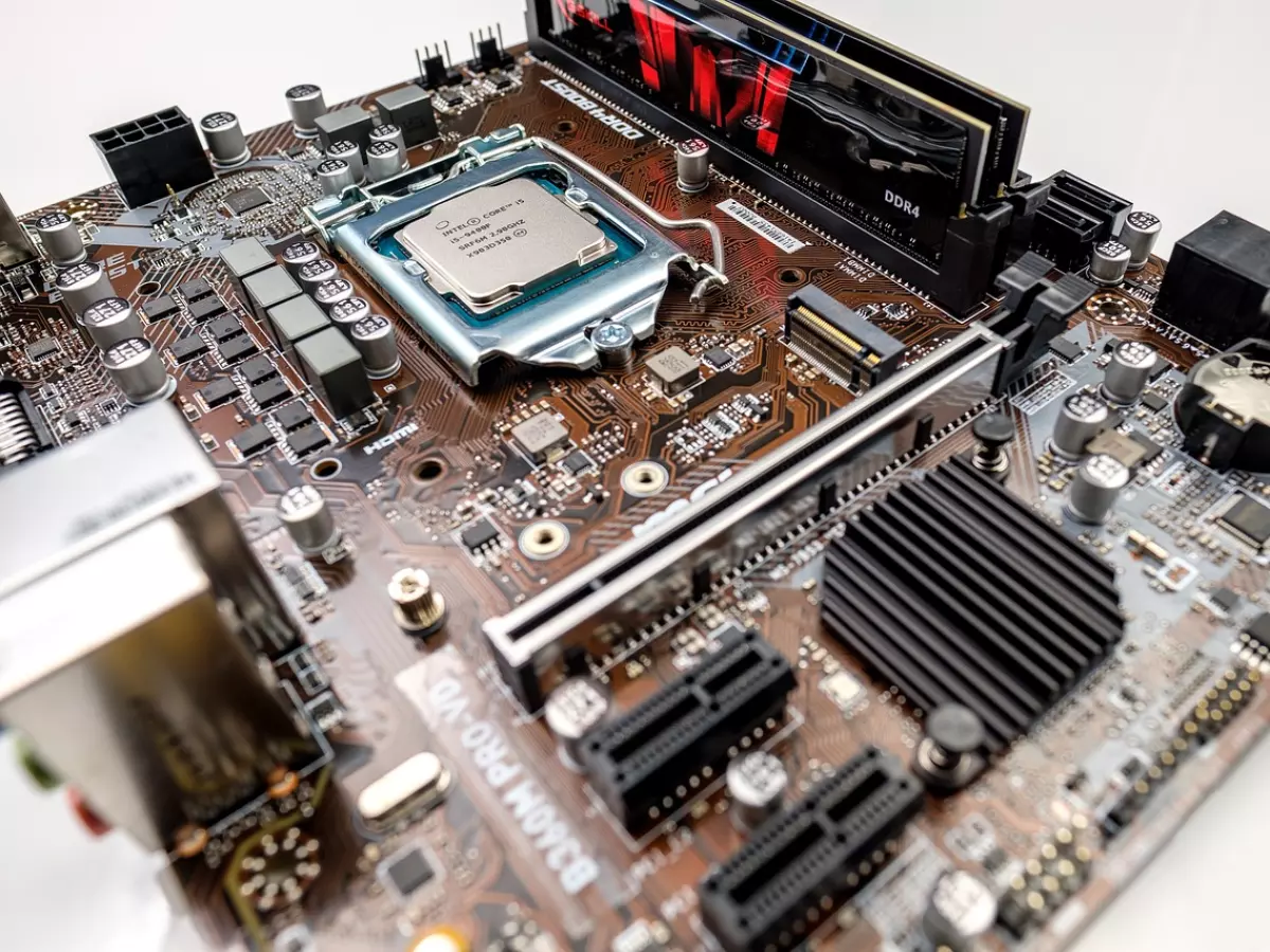 A close-up shot of a computer motherboard with components like the CPU, RAM, and other connectors. The motherboard is a key component in any computer system, providing connectivity and communication pathways for all the other components.