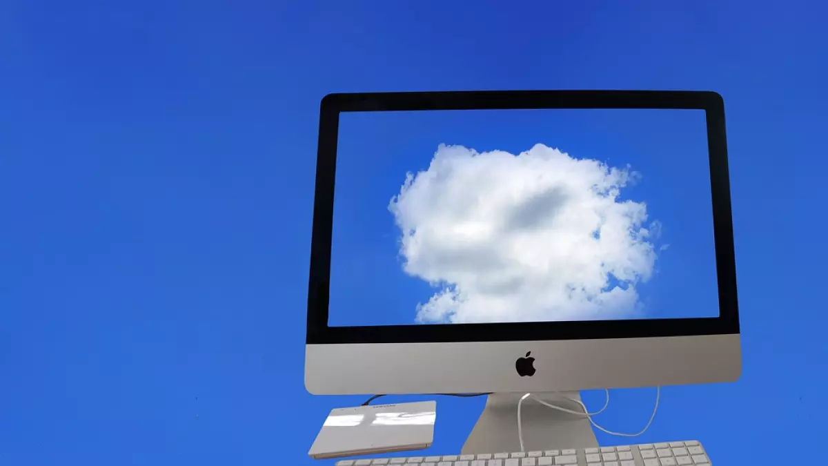 A computer displaying a cloud in the sky.