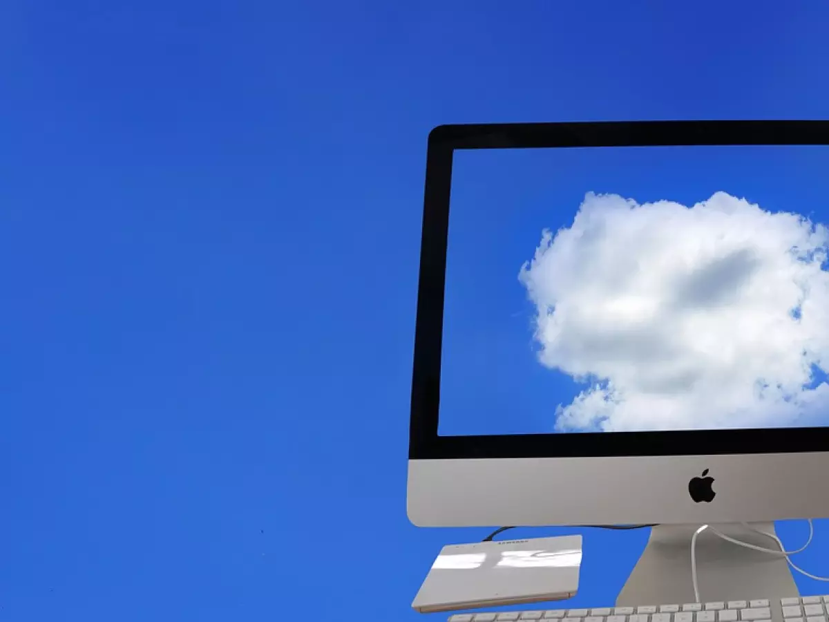 A computer displaying a cloud in the sky.