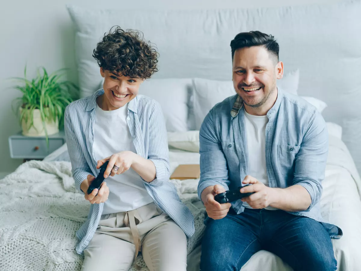 Two people playing video games on a couch.