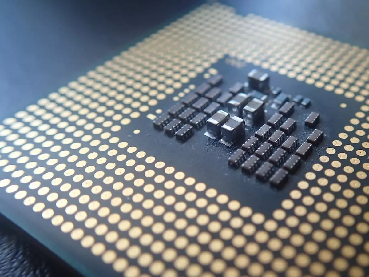 A close-up shot of a computer processor chip with gold connectors and black components.