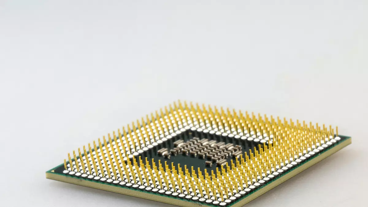 A close-up image of a computer processor chip, with gold pins and a square shape.