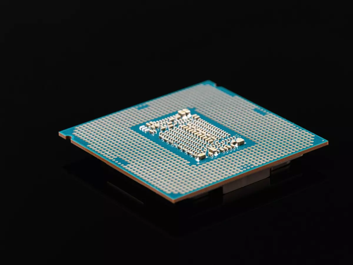 A CPU chip on a black background. The chip is blue and has a shiny surface.