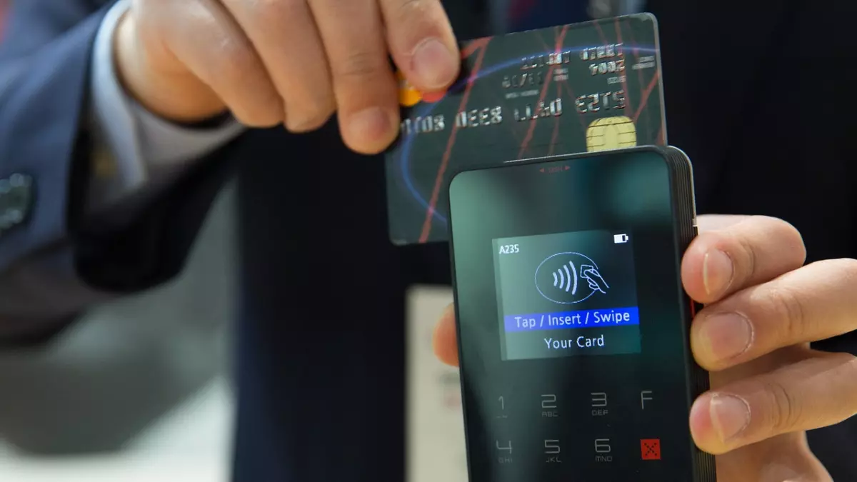 Close up of a person using a card payment terminal.