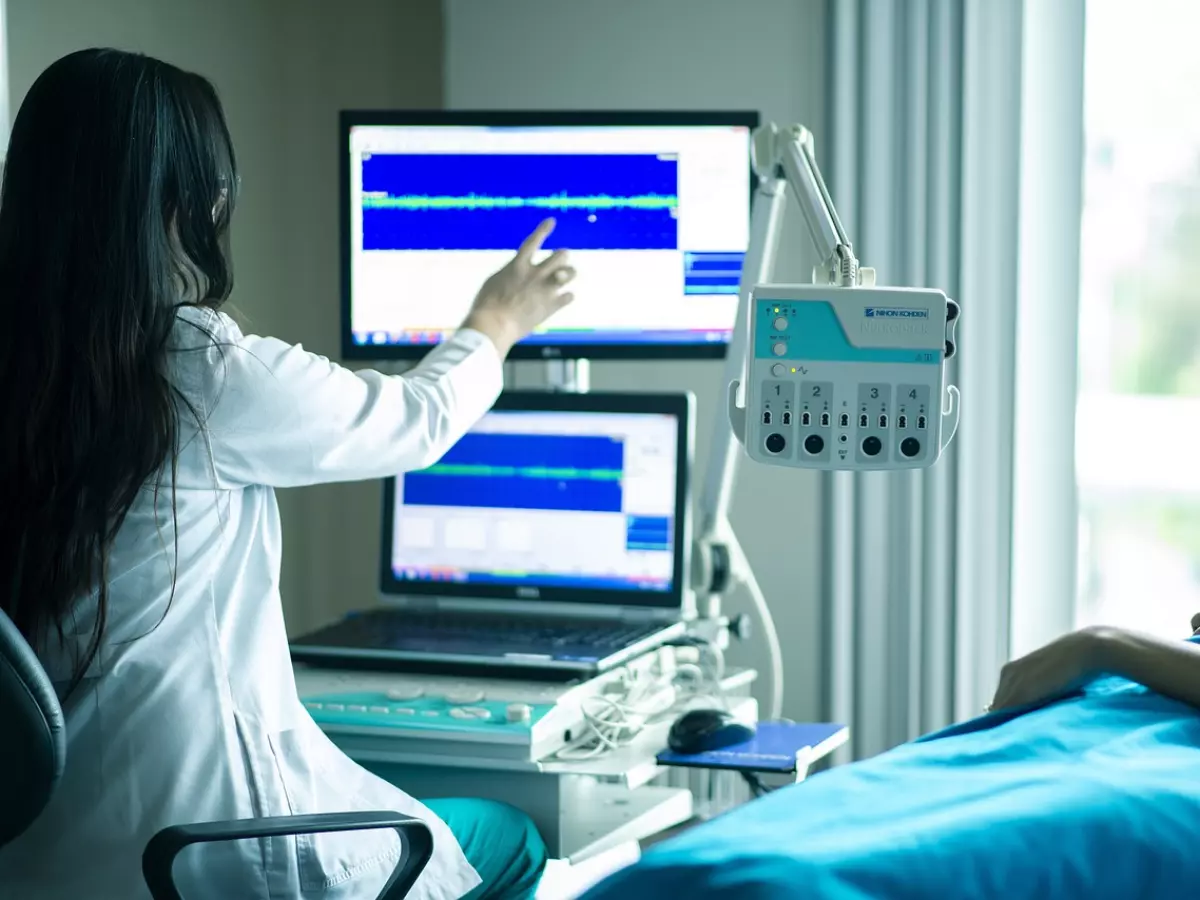 A doctor is looking at a monitor in a medical setting. 