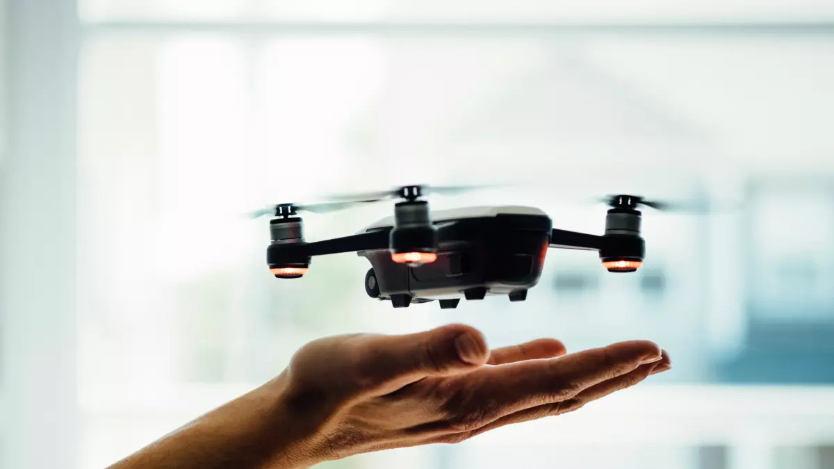 A close-up photo of a drone hovering above a person