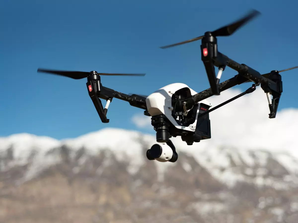 A drone flies over a mountain landscape, showcasing its autonomous navigation capabilities.