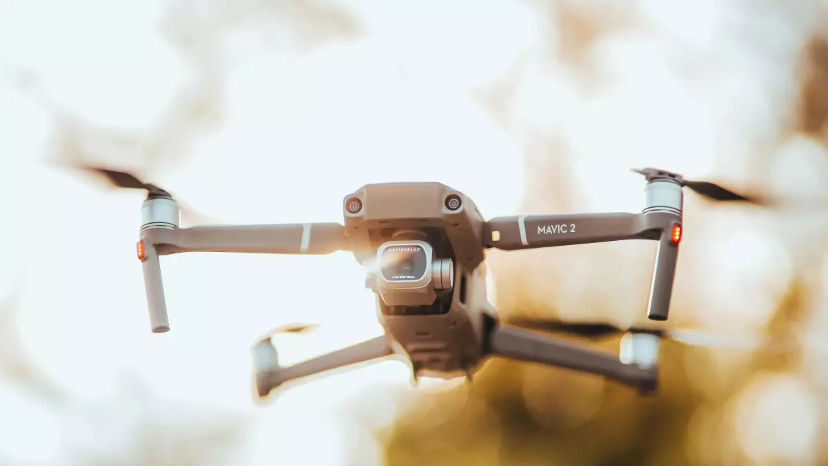 A drone flying in the air with a blurred background.