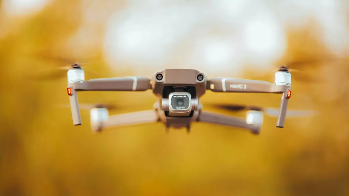 Close-up of a drone in flight against a blurred background of autumnal colors.