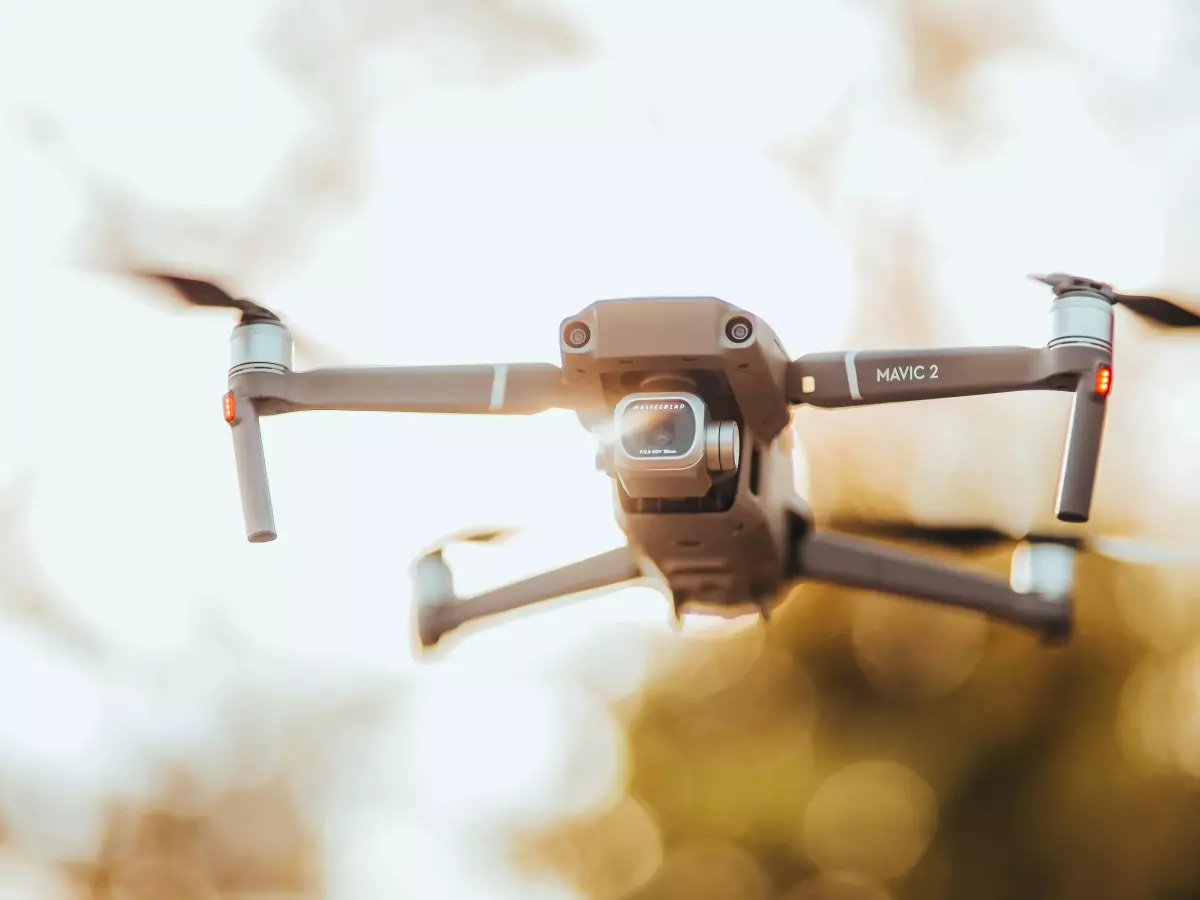 A drone flying in the air with a blurred background.