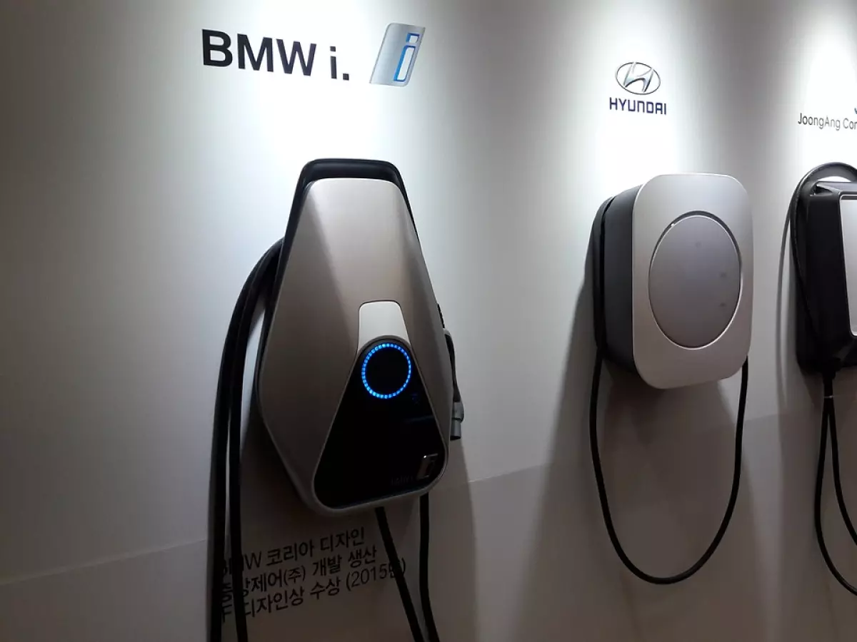 A display of different electric vehicle charging stations from various manufacturers like BMW, Hyundai, and others.