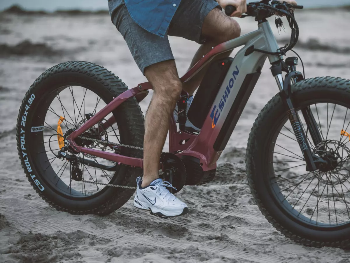 A person riding an e-bike with thick tires on a dirt road.