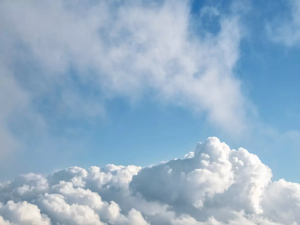 A sky with dramatic clouds, some white and fluffy, others dark and stormy.