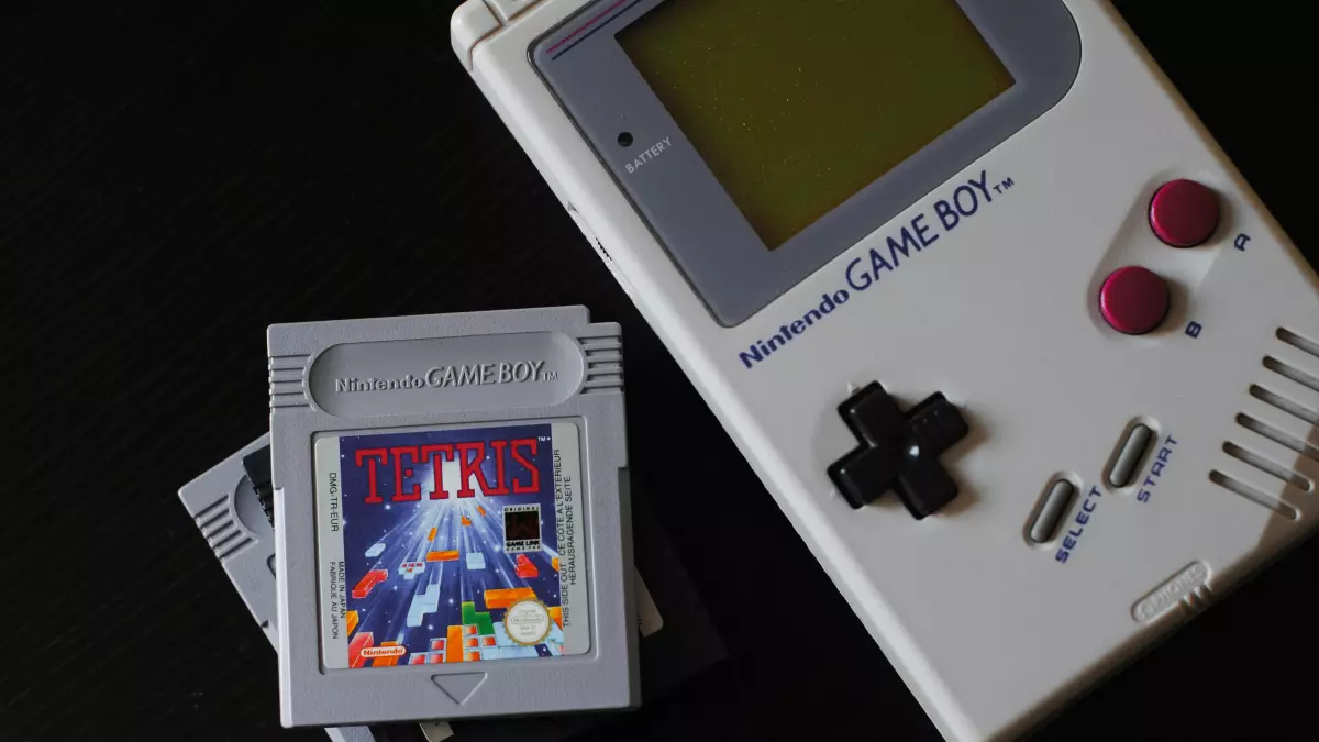 A classic Nintendo Game Boy with three cartridges.