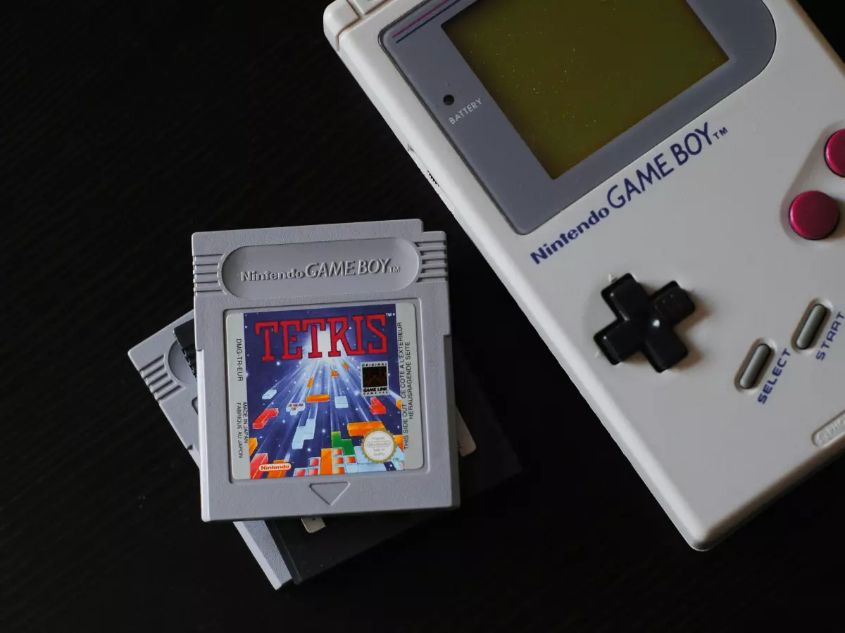 A classic Nintendo Game Boy with three cartridges.