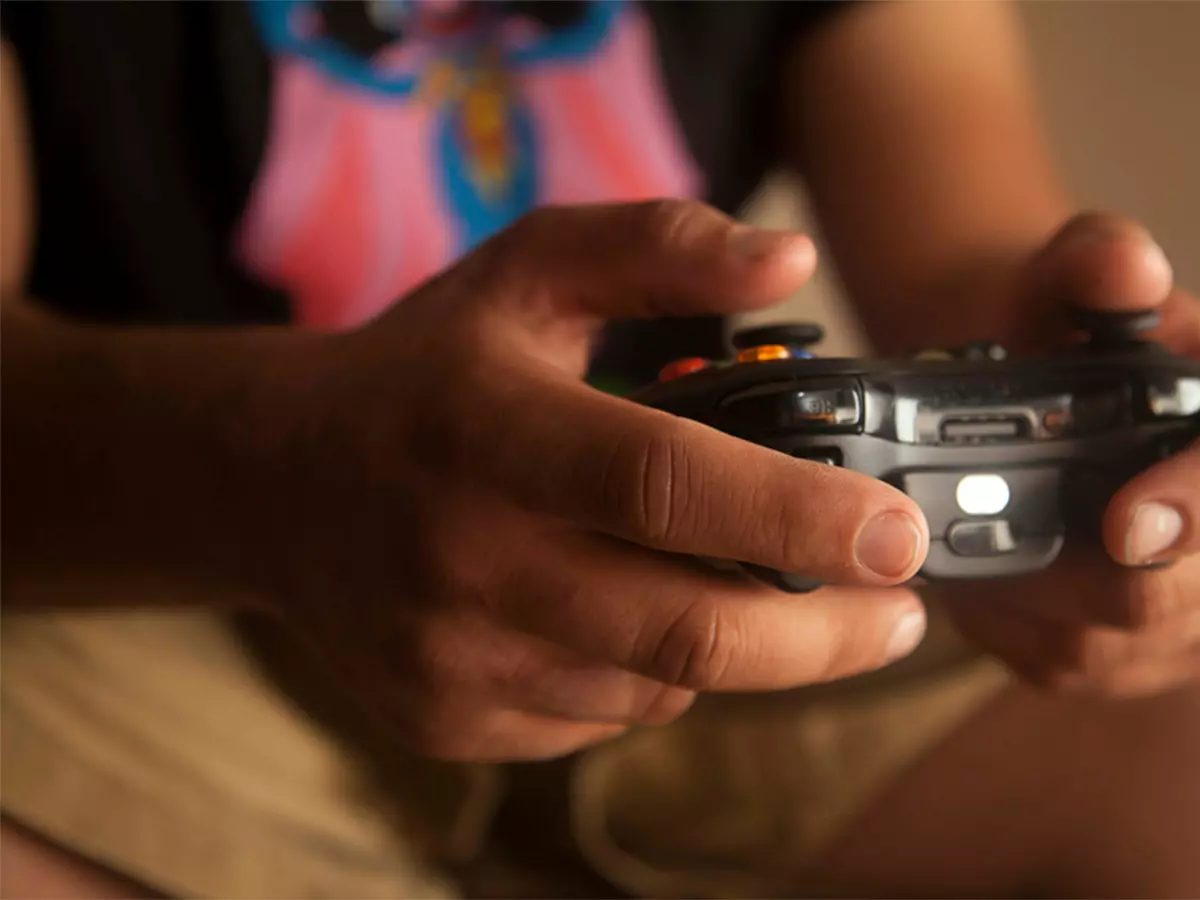 A person is holding an Xbox controller and playing a game.