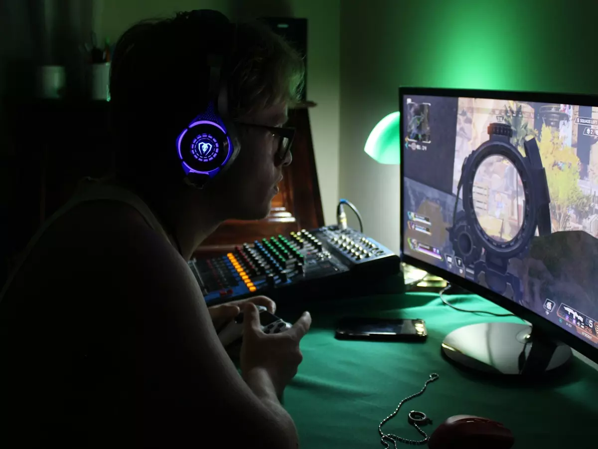 A man playing a first-person shooter game on a computer.