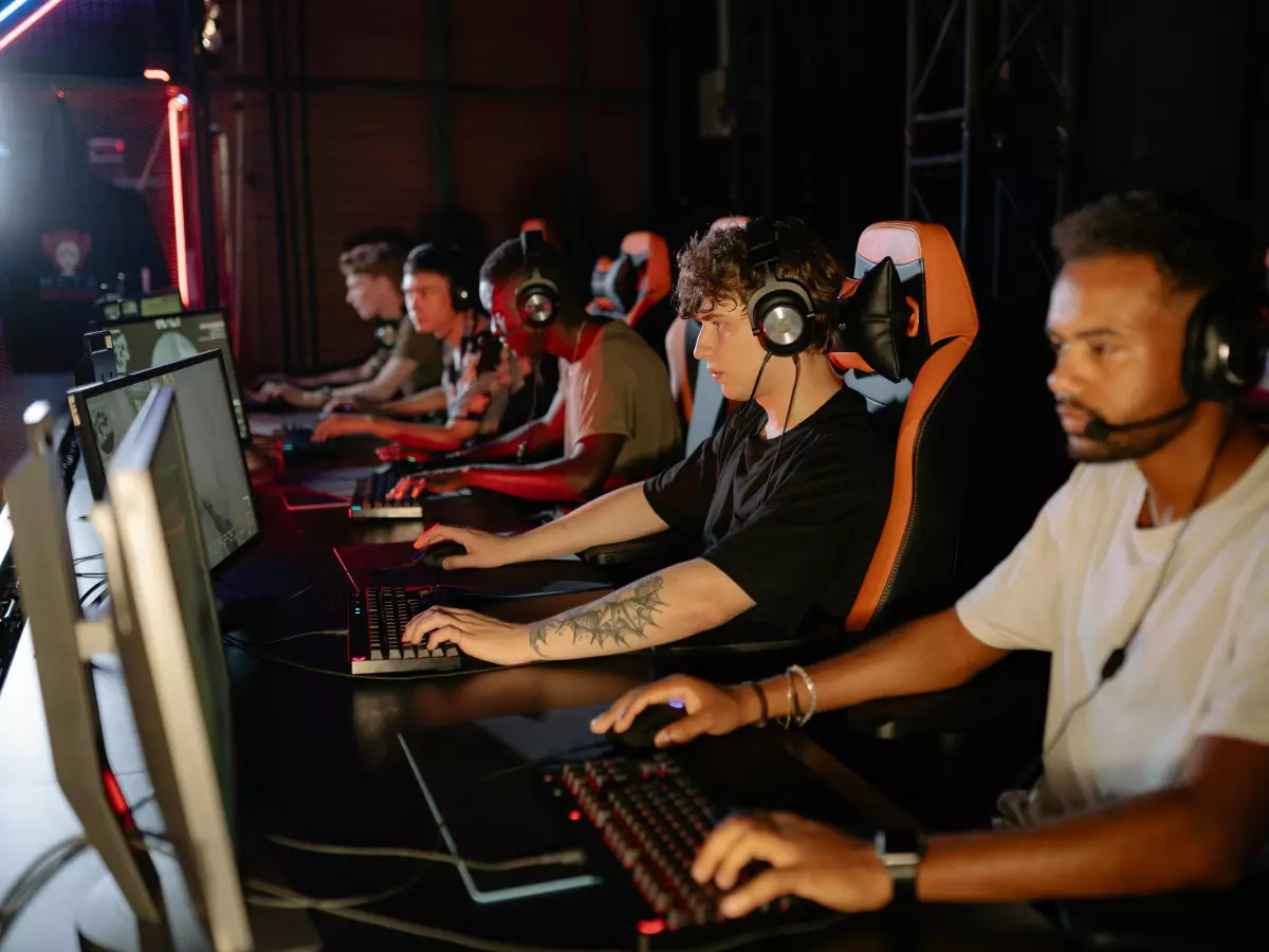 A group of people playing video games at a computer station.