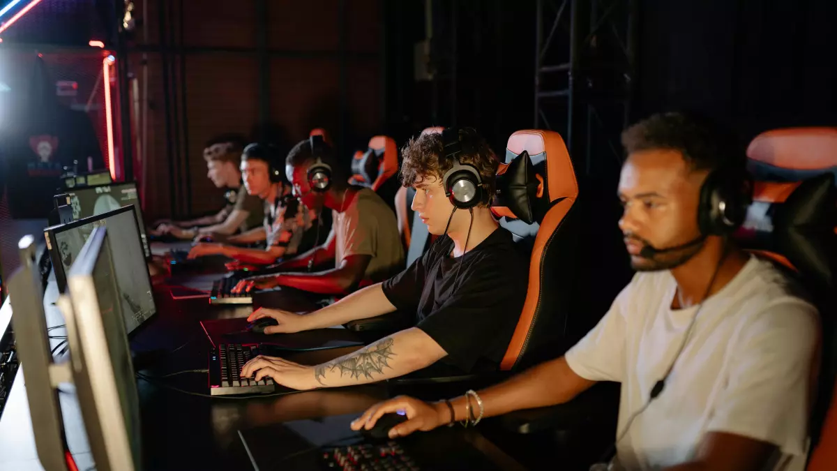 A group of people playing video games at a computer station.