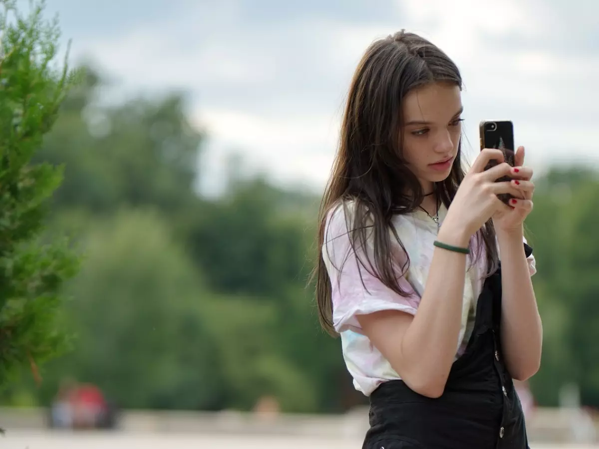 A woman using a smartphone, a close up shot. She is looking at the screen.