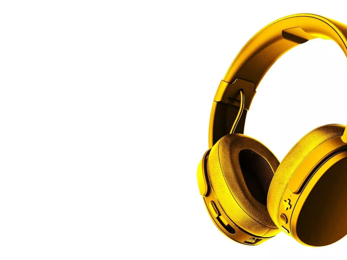 A pair of gold headphones are shown in a close-up shot against a white background.