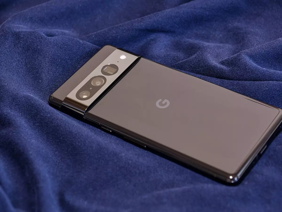 A Google Pixel 9 Pro phone lying on a blue cloth, showing its back camera system and the Google logo.