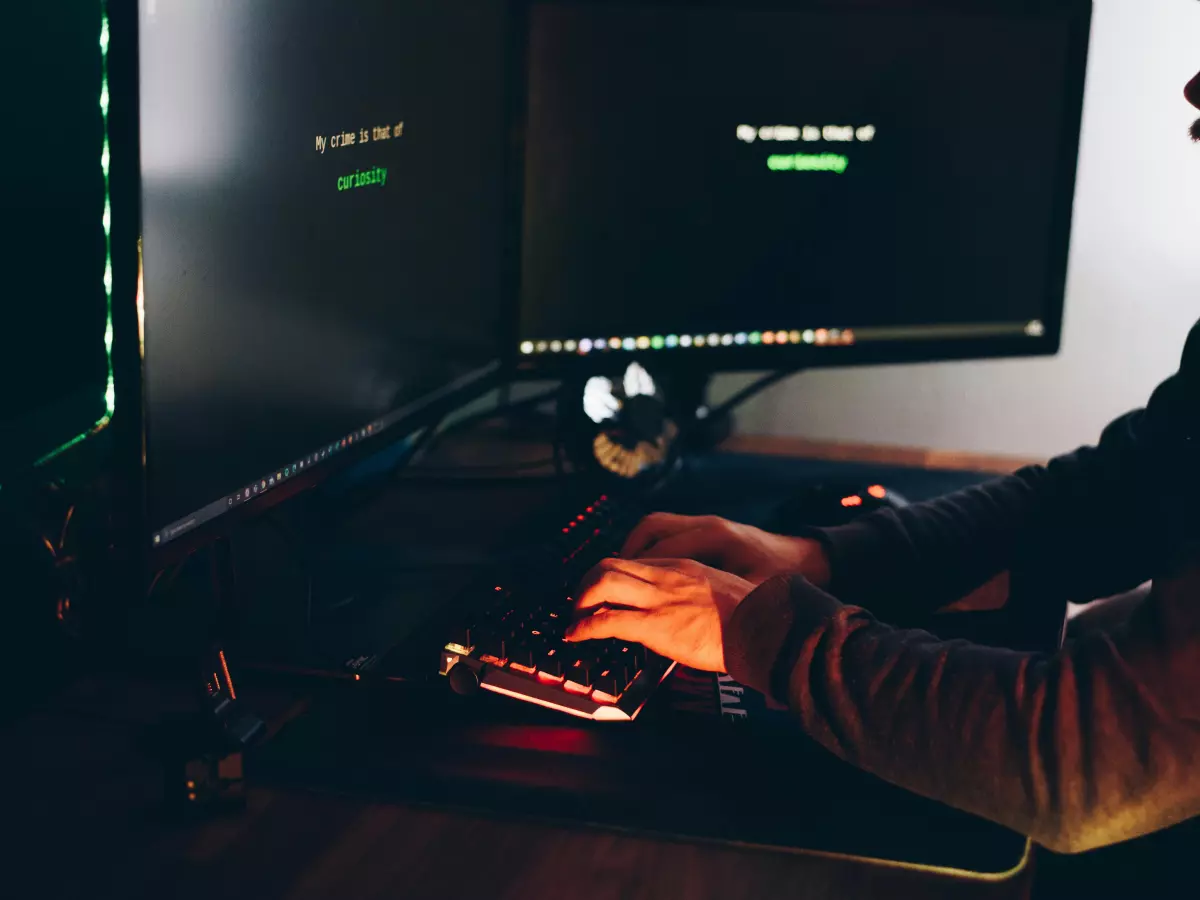 A person working on a computer in a dimly lit room.