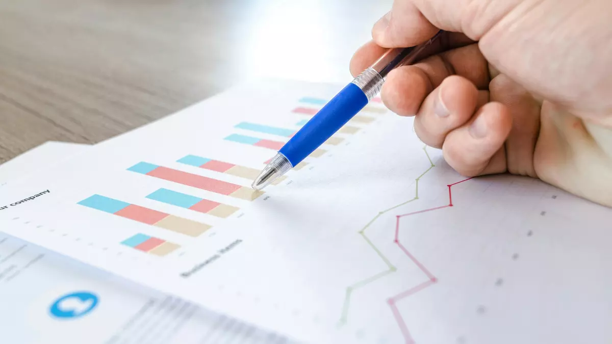 A hand pointing at a graph on a piece of paper.