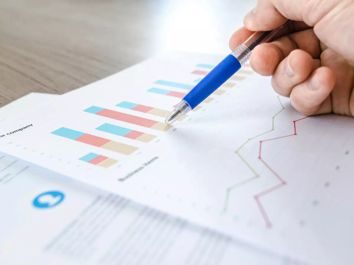 A hand pointing at a graph on a piece of paper.