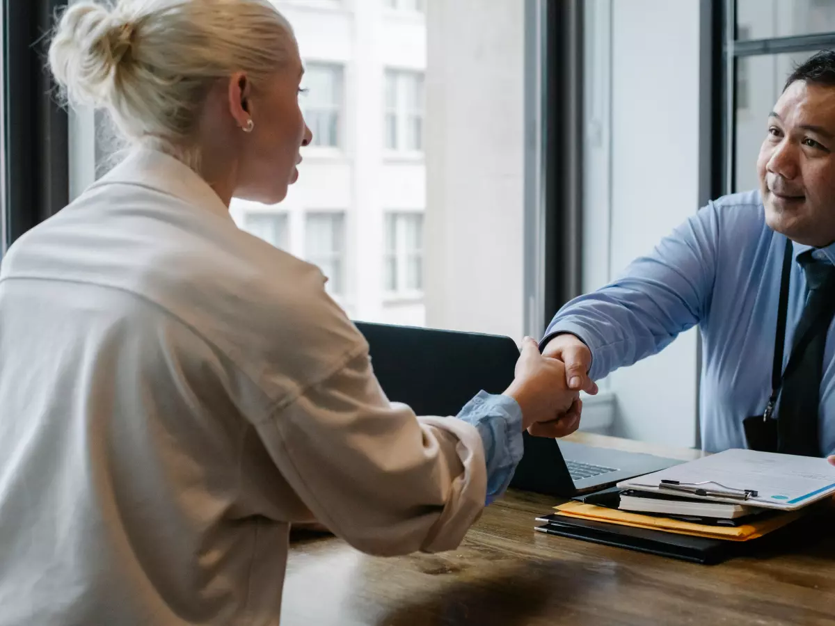 Two people shaking hands in a business meeting.